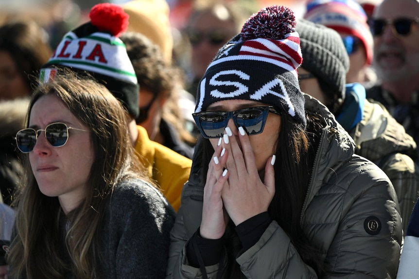 An American fan covers her face.