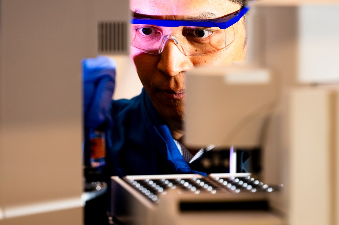 A researcher with googles examines a device.