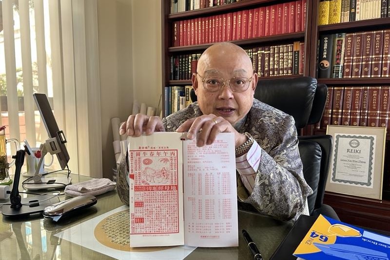  A man holds up a book of feng shui