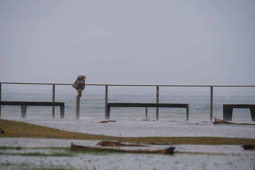Photo taken of the ocean from a promenade in the rain.