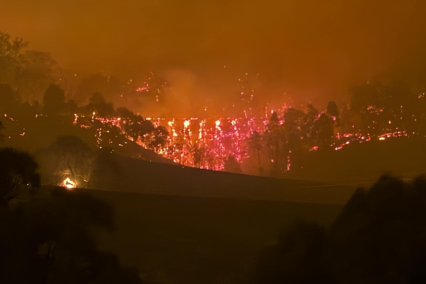flames consuming a bridge in a burning landscape