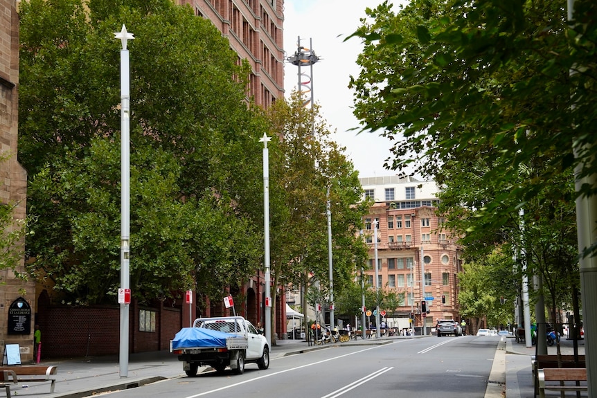 A Sydney street with high-rise buildings and cars on the road.