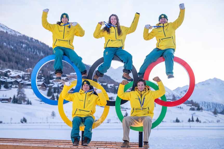 Jakara Anthony, Josie Baff, Cooper Woods, Matt Graham and Scotty James sit inside the Olympic rings.