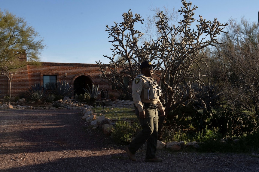A Pima County Sheriff's Department deputy patrols at the home of Nancy Guthrie.