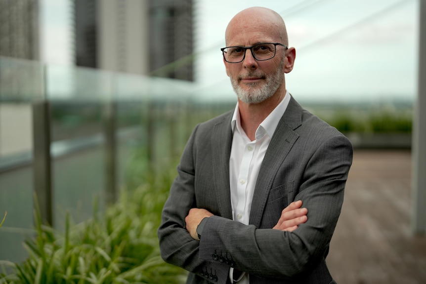 A man wearing a suit with his arms crossed.