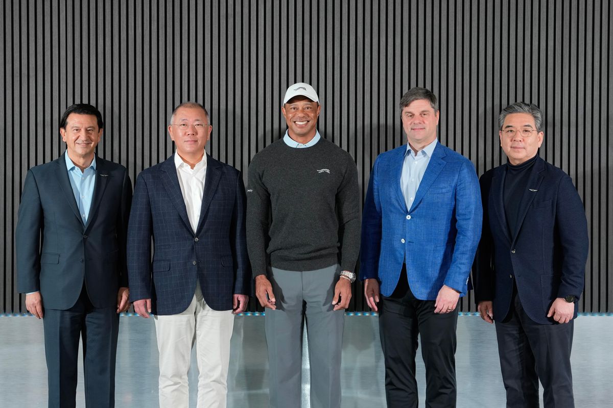Tiger Woods poses for a photo with the President and CEO of Genesis, Jose Munoz