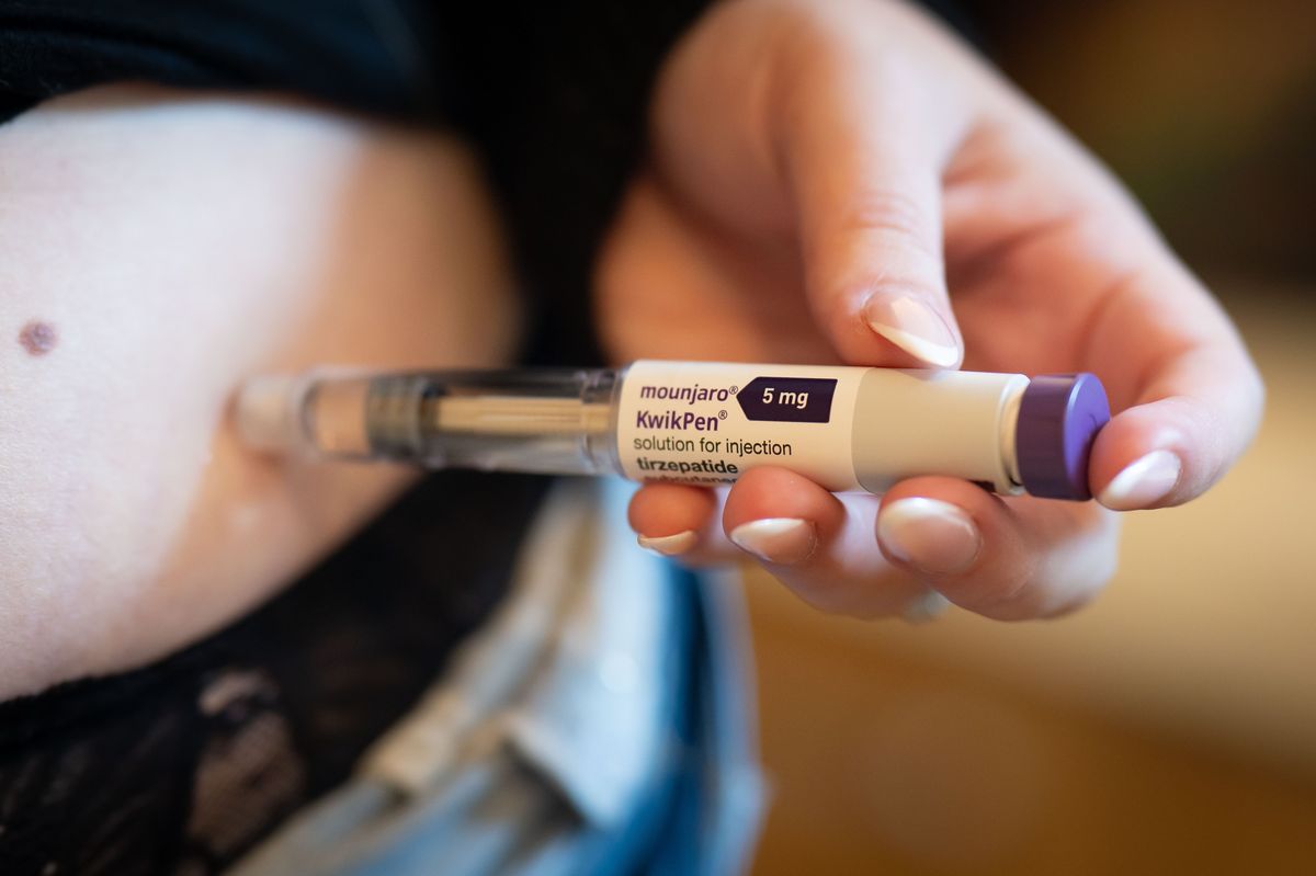 A woman uses a Mounjaro injection pen on October 4, 2025 in Cardiff, Wales.