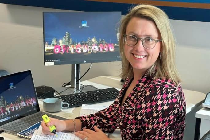A woman sits at her desk in an office.