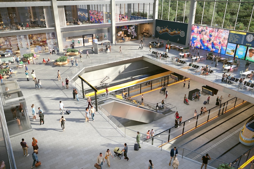 An aerial view of a multi level train station with escalators.
