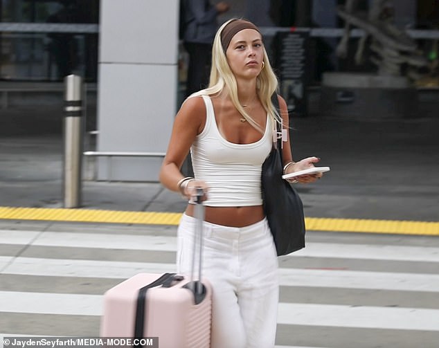 Kleverlaan wore a white sleeveless top and loose‑fitting pants, accessorising with a black shoulder bag and brown headband