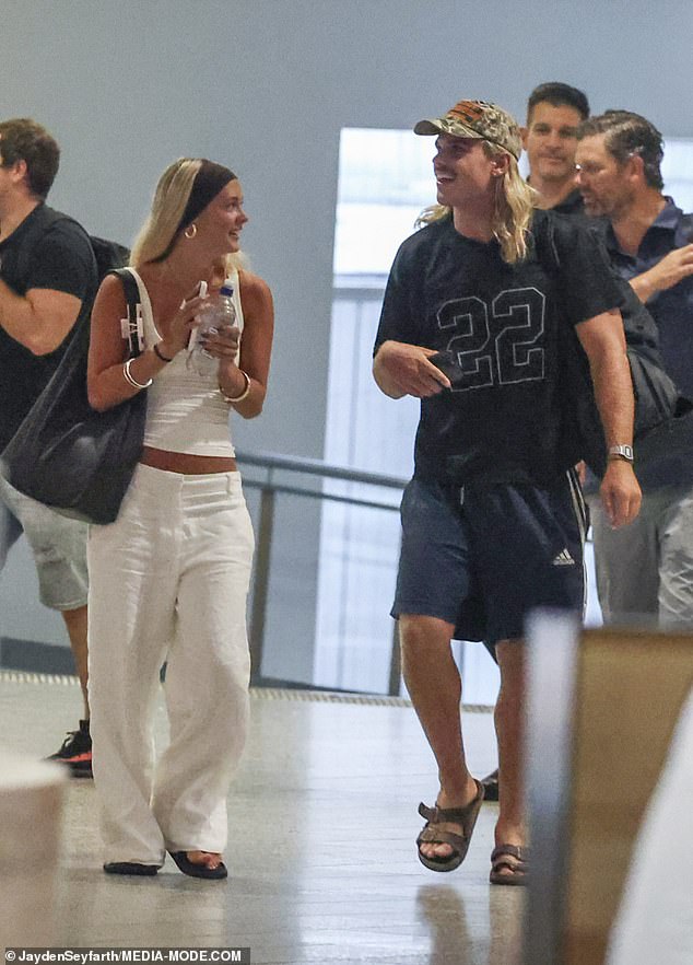 The pair dressed casually when we saw them at Melbourne Airport, with Smith opting for an oversized black T-shirt, navy shorts, slides and a camouflage cap