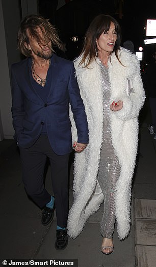She paired the figure-hugging gown with a huge white fur coat