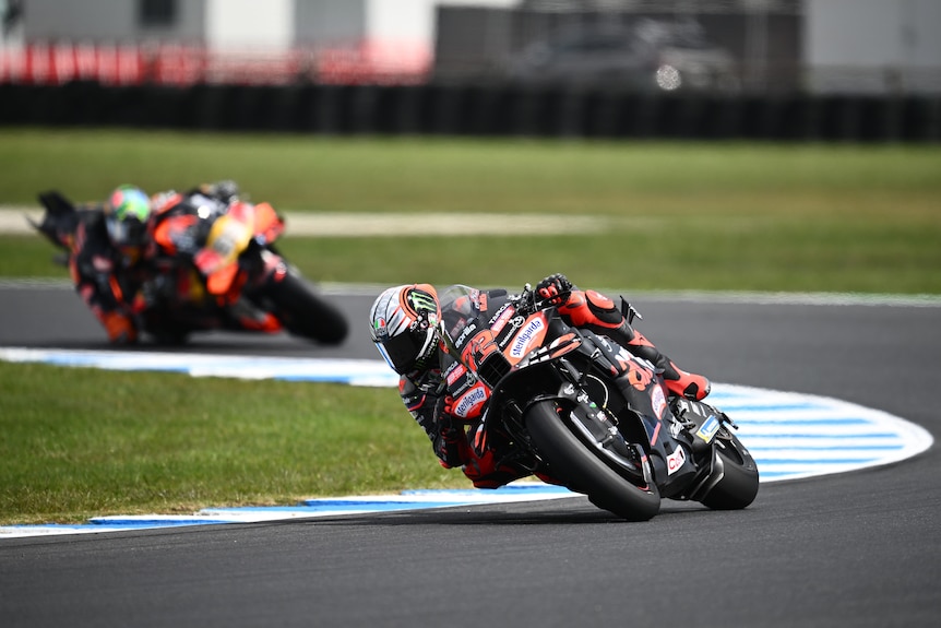 MotoGP rider going around a corner on his motorcycle.