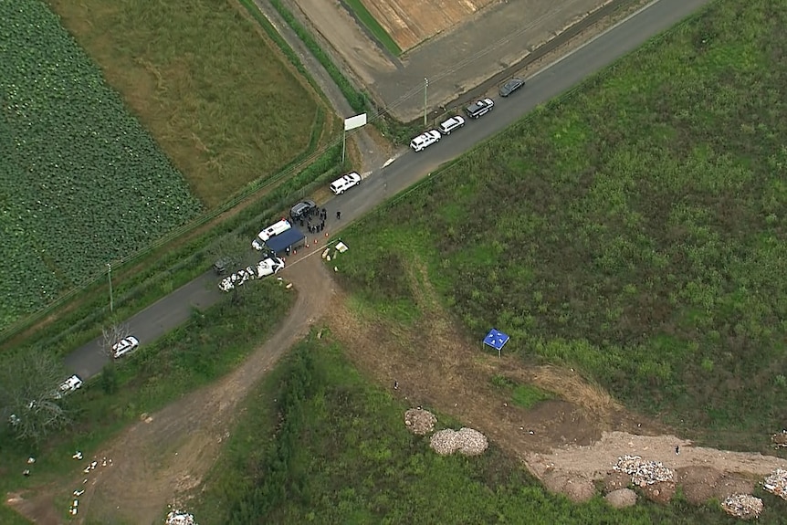 An aerial image showing police cars and officers in bushland.