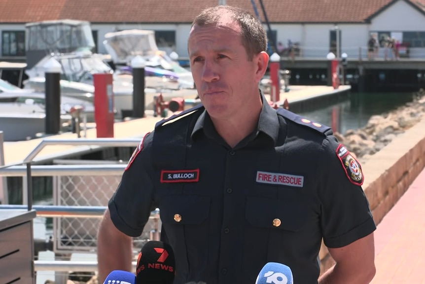 DFES officer Scott Bulloch speaks to reporters while wearing his uniform.