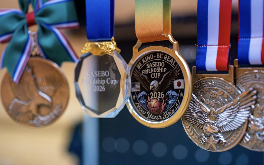 A close-up view of several tournament medals hanging from colorful ribbons. 