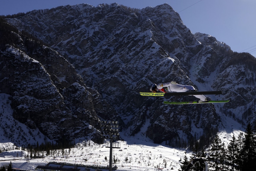 Johannes Lamparter leaps in front of a mountain