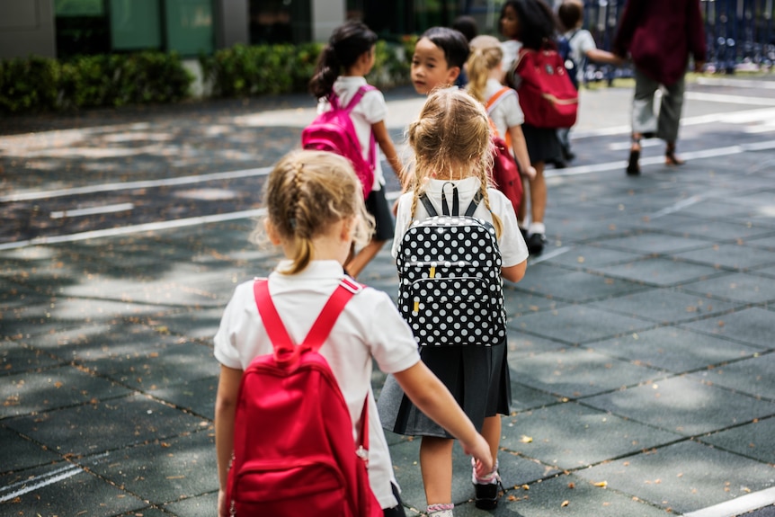 Students line up behind each other in the playground