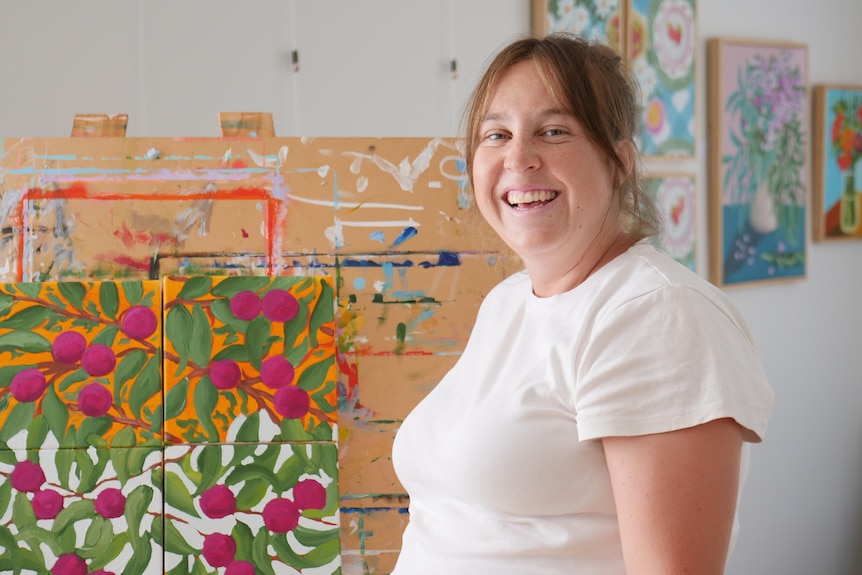 A medium shot of a woman in front of an easel