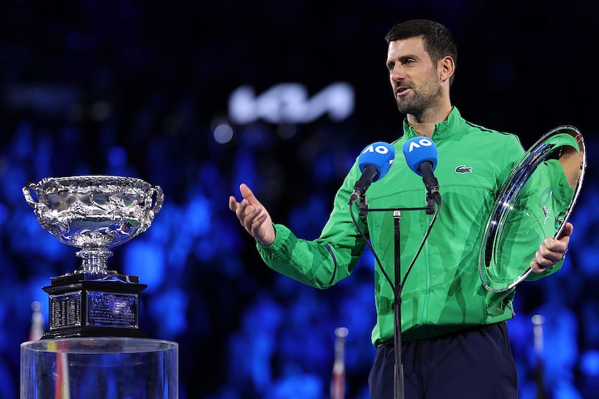 Novak Djokovic of Serbia speaks with finalist plaque at the presentation ceremony