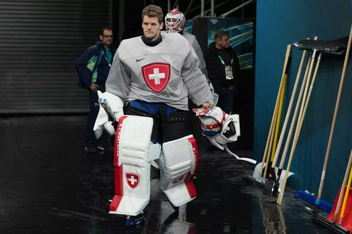 Switzerland's goalkeeper Leonardo Genoni arrives for men's ice hockey practice at the 2026 Winter Olympics, in Milan, Italy, Sunday, Feb. 8, 2026. (AP Photo/Carolyn Kaster)