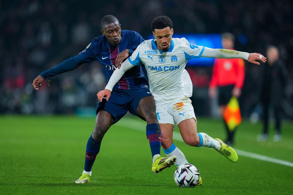 Ethan Nwaneri of Olympique de Marseille competes for the ball with Nuno Mendes of PSG during the Ligue 1 McDonald's match between Paris Saint-Germain FC and Olympique de Marseille