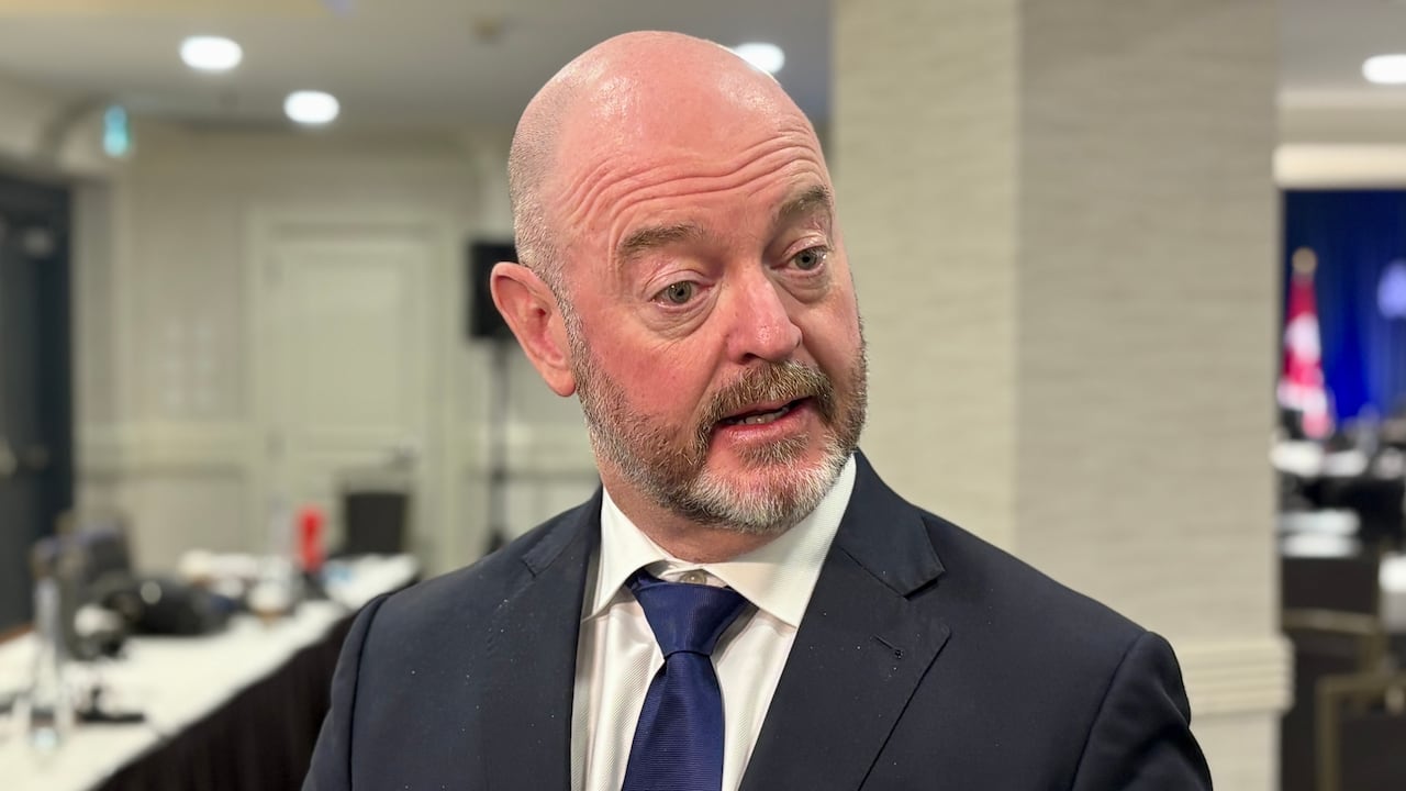 Man in suit looks off camera