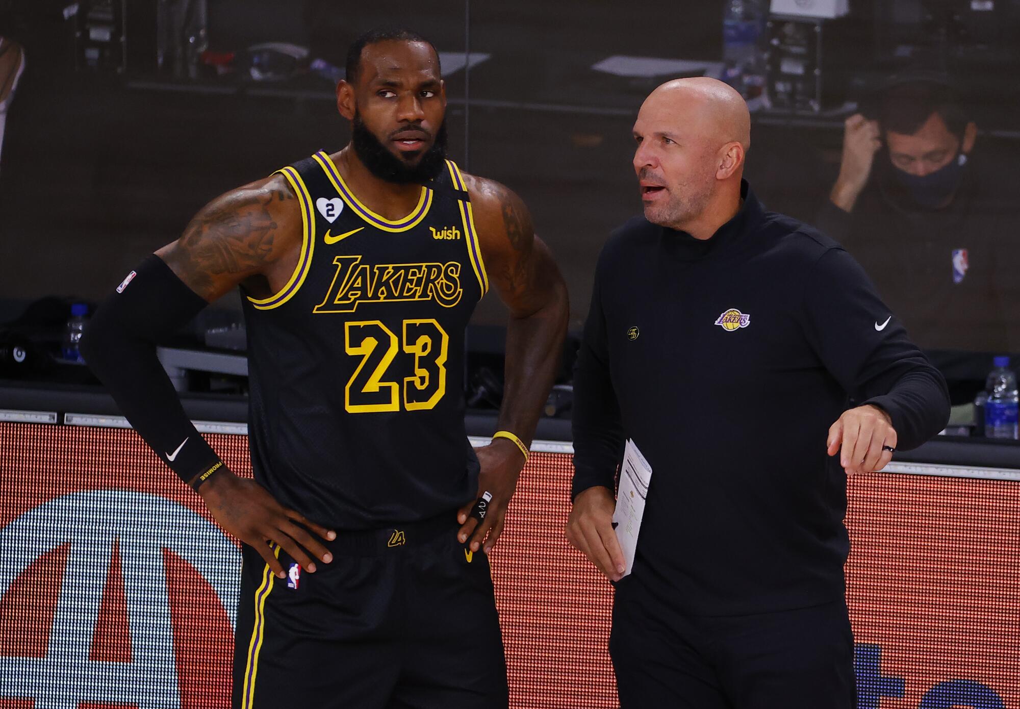 Lakers forward LeBron James, right, talks with assistant coach Jason Kidd, right, during a 2020 playoff game against Portland