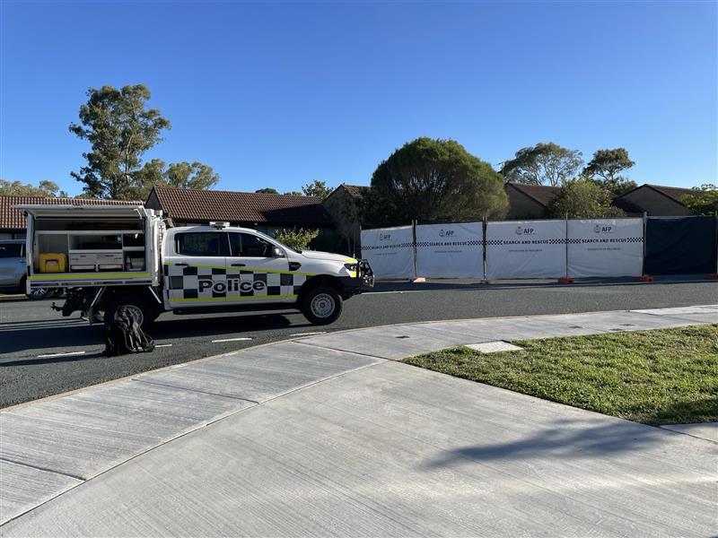Police cars and a police barrier set up at the scene