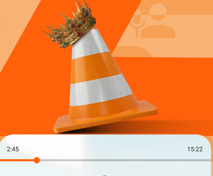 Orange VLC traffic cone wearing a golden crown above a media playback progress bar.