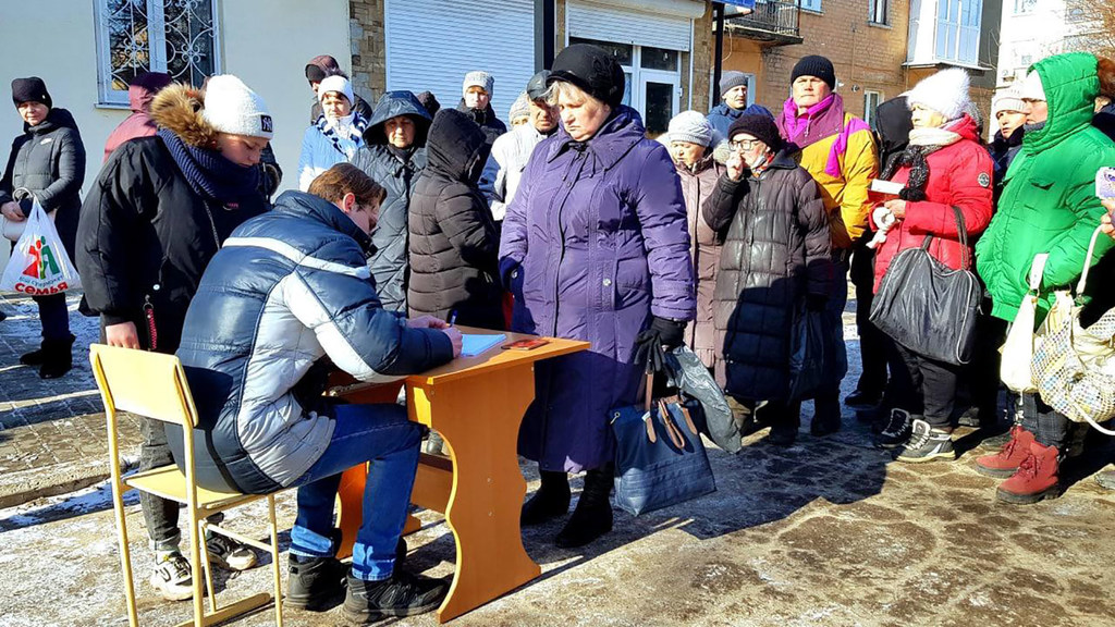 Women fleeing the combat zones of Donetsk and Luhansk oblasts stand in line to receive humanitarian aid. Women fleeing the combat zones of Donetsk and Luhansk oblasts stand in line to receive humanitarian aid.