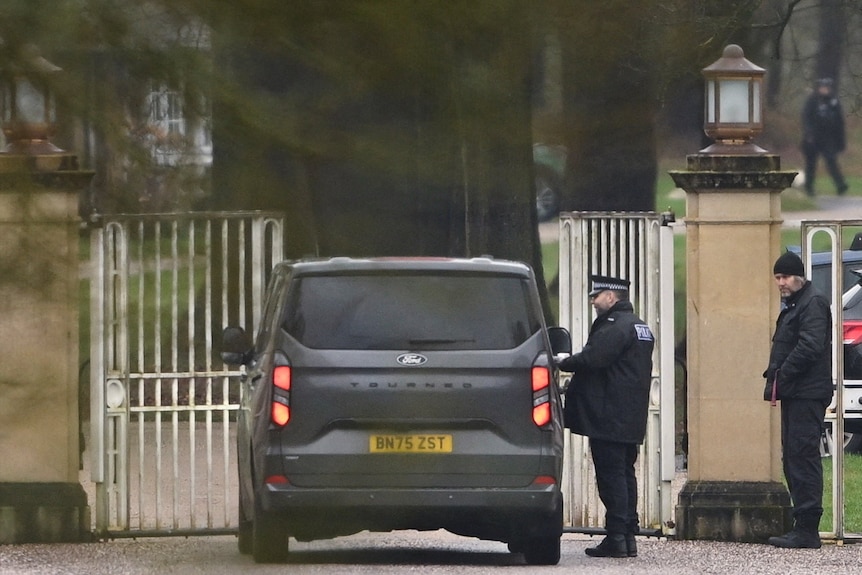 A police officer talks to a driver inside a car outside Royal Lodge on the Windsor Estate.
