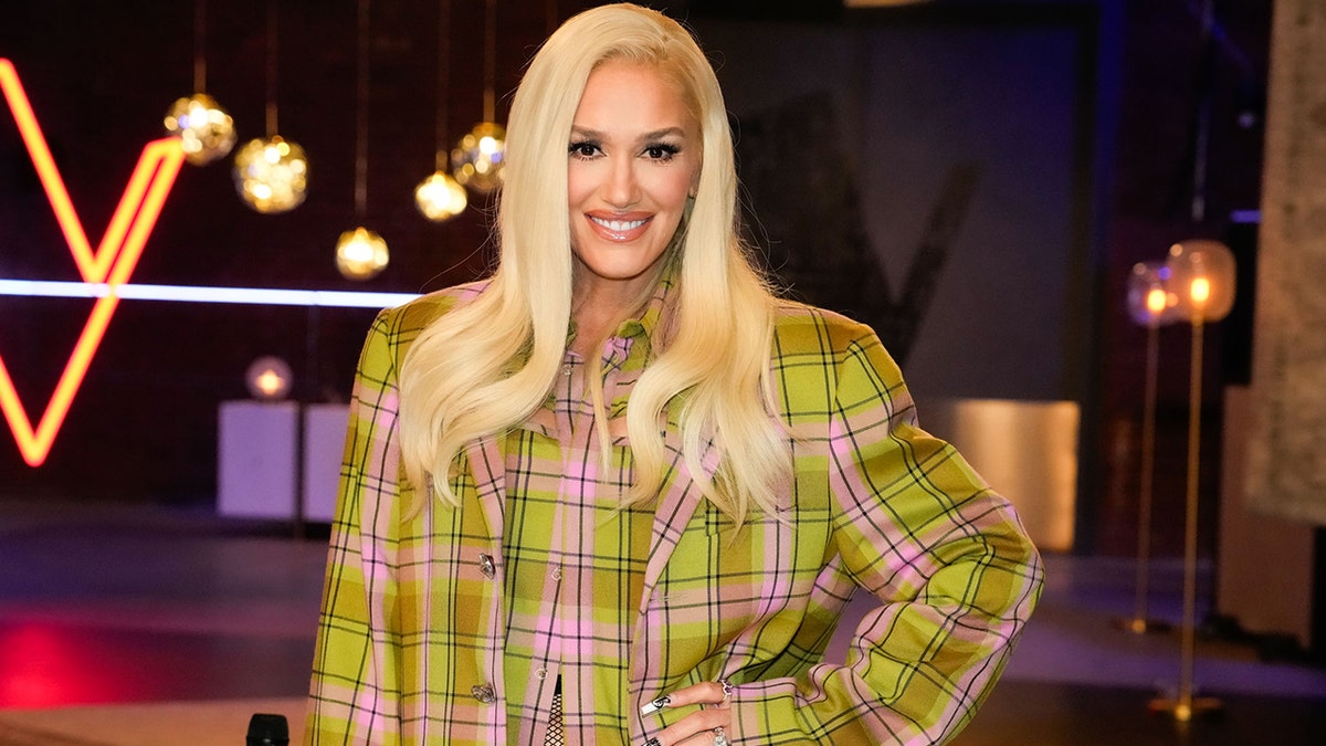 Gwen Stefani smiling in pink and green plaid suit