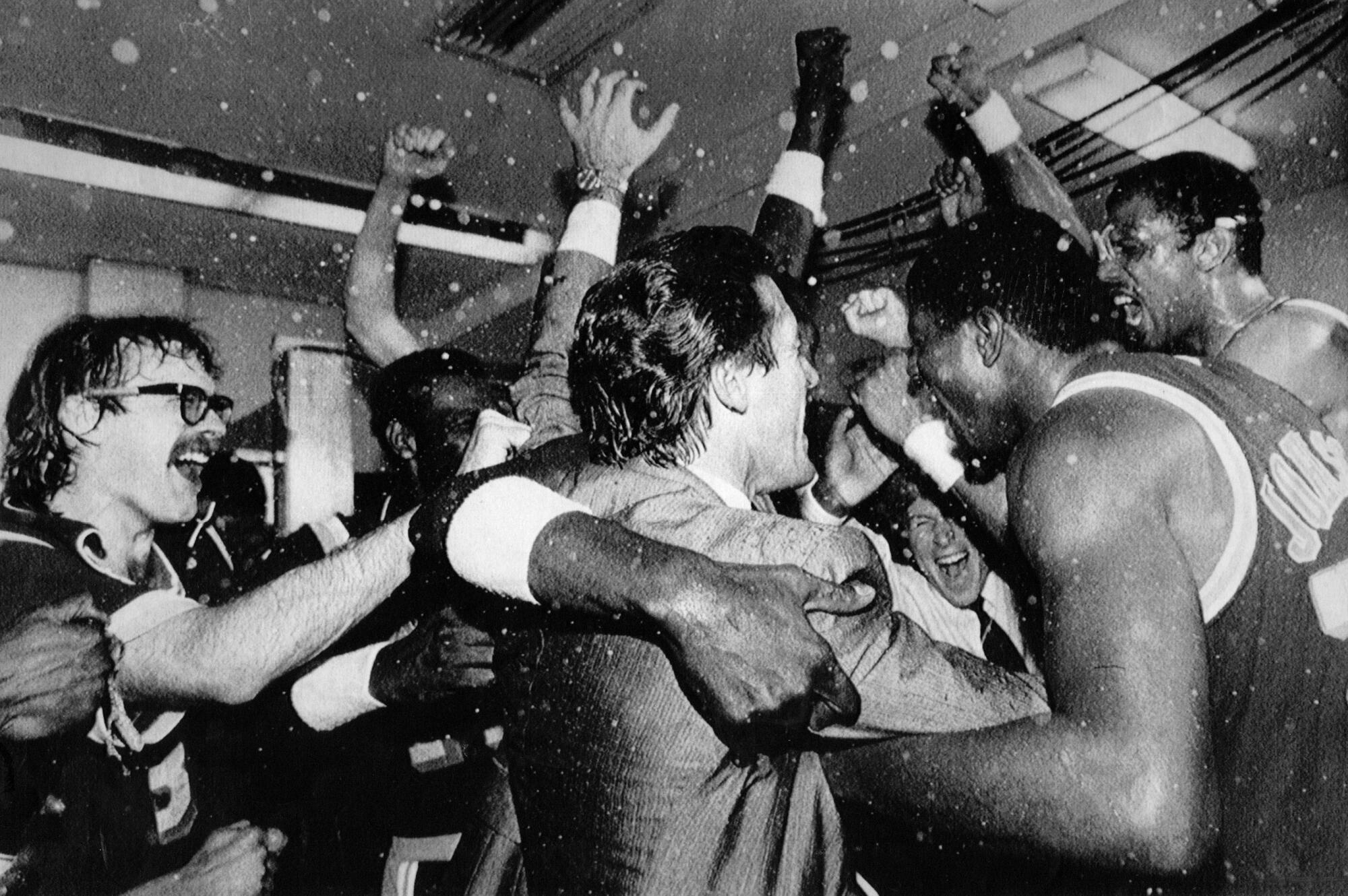 Lakers coach Pat Riley celebrates with players, including Kurt Rambis, left, and Magic Johnson, right, as 1985 NBA champions.