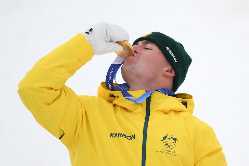 Cooper Woods kisses his gold medal at the Milano Cortina Winter Olympics.