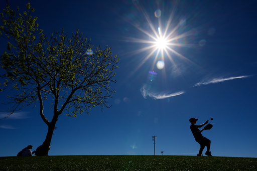 Logan Eaton, age 9, plays catch in the outfield before a spring training baseball game between the Texas Rangers and the Colorado Rockies, Sunday, Feb. 22, 2026, in Surprise, Ariz. (AP Photo/Charlie Riedel)