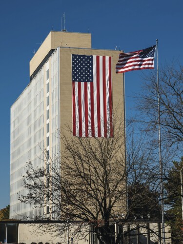 A tall building with an American flag on one side of it.