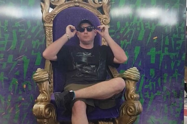 a man with sunglasses sits in a large chair