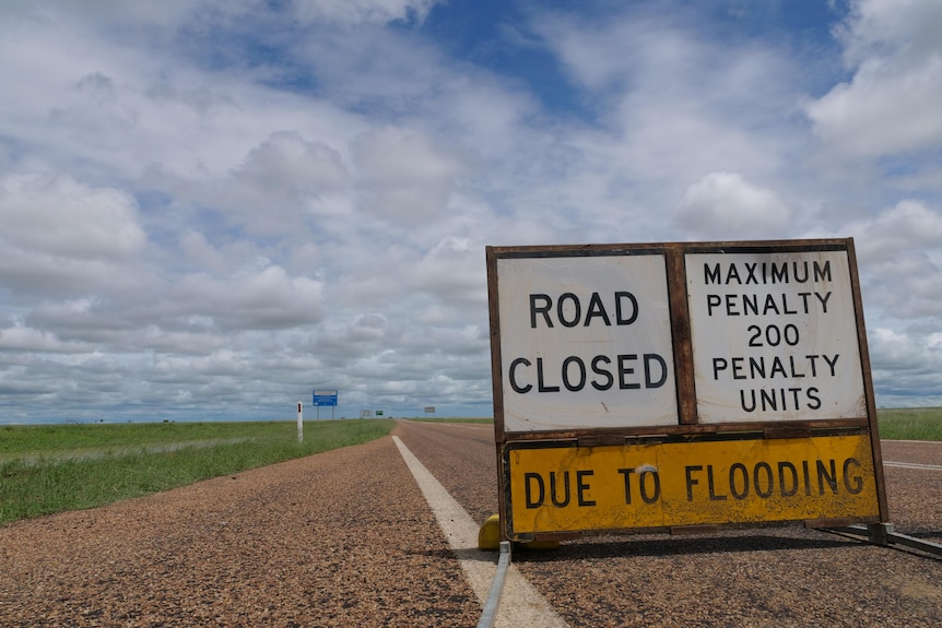 a road closed sign in the middle of road in western queensland