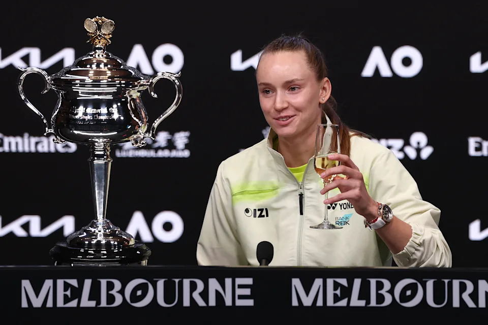Kazakhstan's Elena Rybakina drinks champagne at the start of her press conference after defeating Belarus' Aryna Sabalenka in the women's singles final on Day 14 of the Australian Open tennis tournament in Melbourne on January 31, 2026. (Photo by IZHAR KHAN / AFP via Getty Images) / -- IMAGE RESTRICTED TO EDITORIAL USE - STRICTLY NO COMMERCIAL USE --