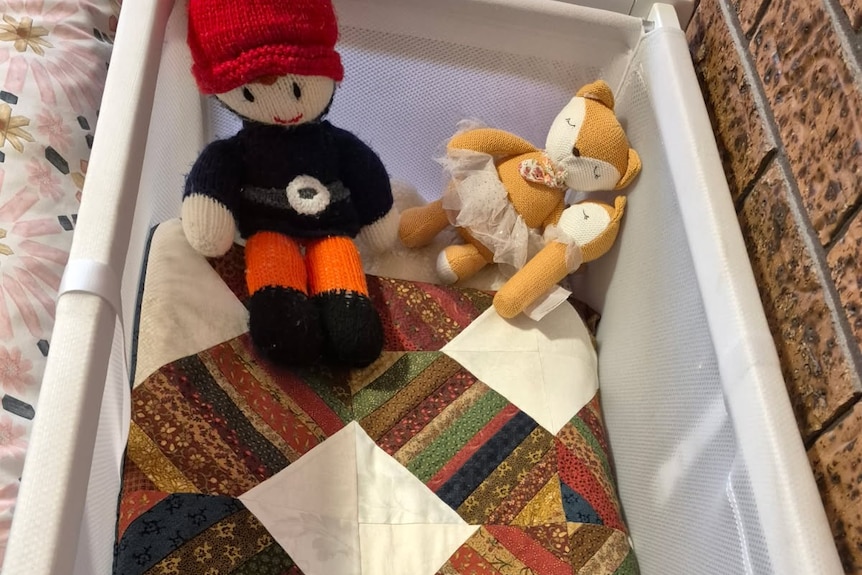 A colourful quilt folded inside a baby crib.