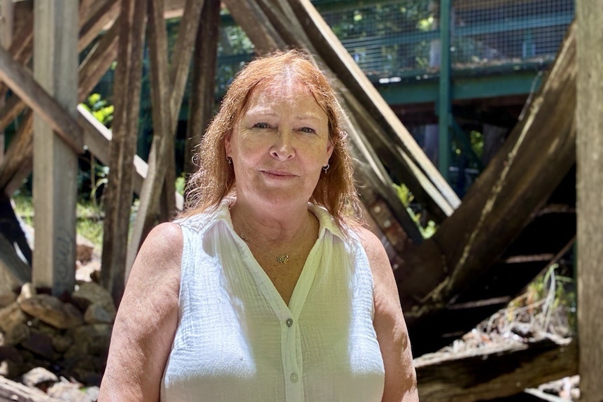 A woman looks to the camera smiling slightly. 