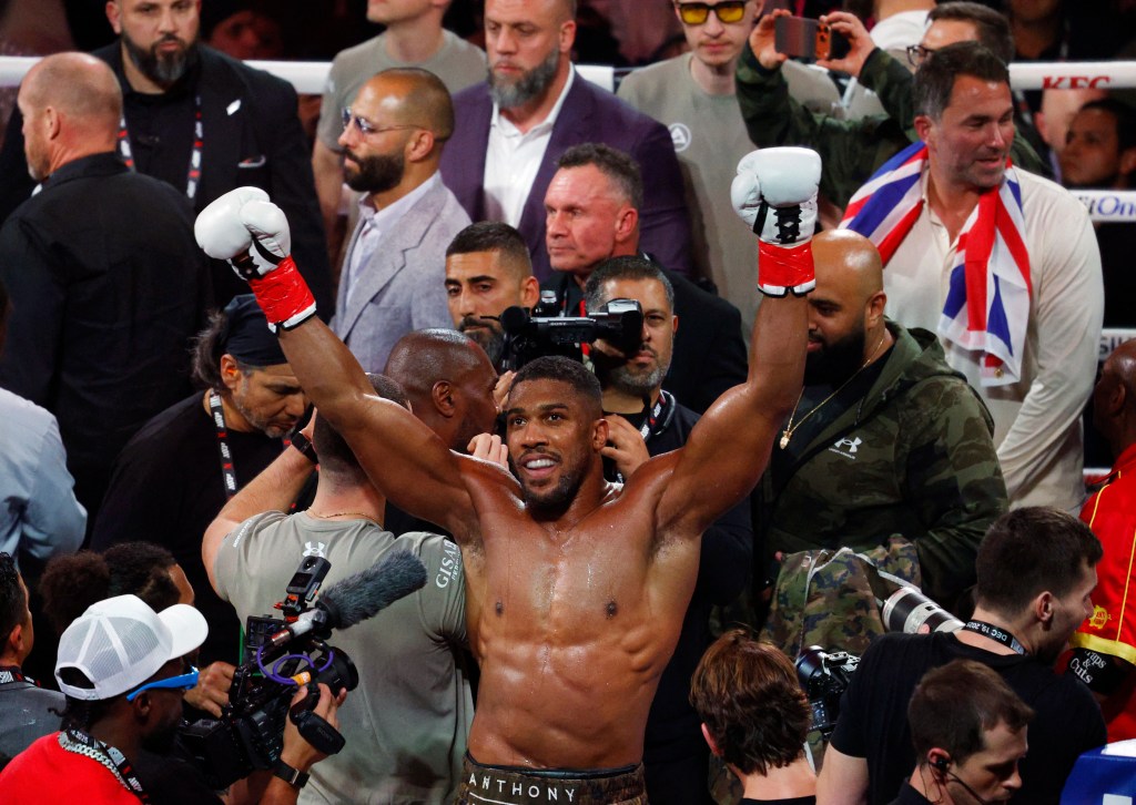 Anthony Joshua celebrating his victory over Jake Paul with arms raised.
