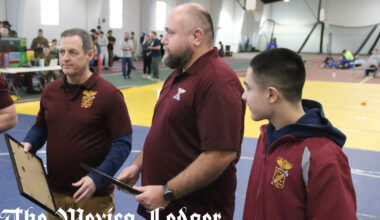 Missouri Military Academy coaches Levi Iman (middle) and Thomas Allen hold their presents from their senior wrestlers on Feb. 7 during the MMA Colonels Classic in Mexico.
