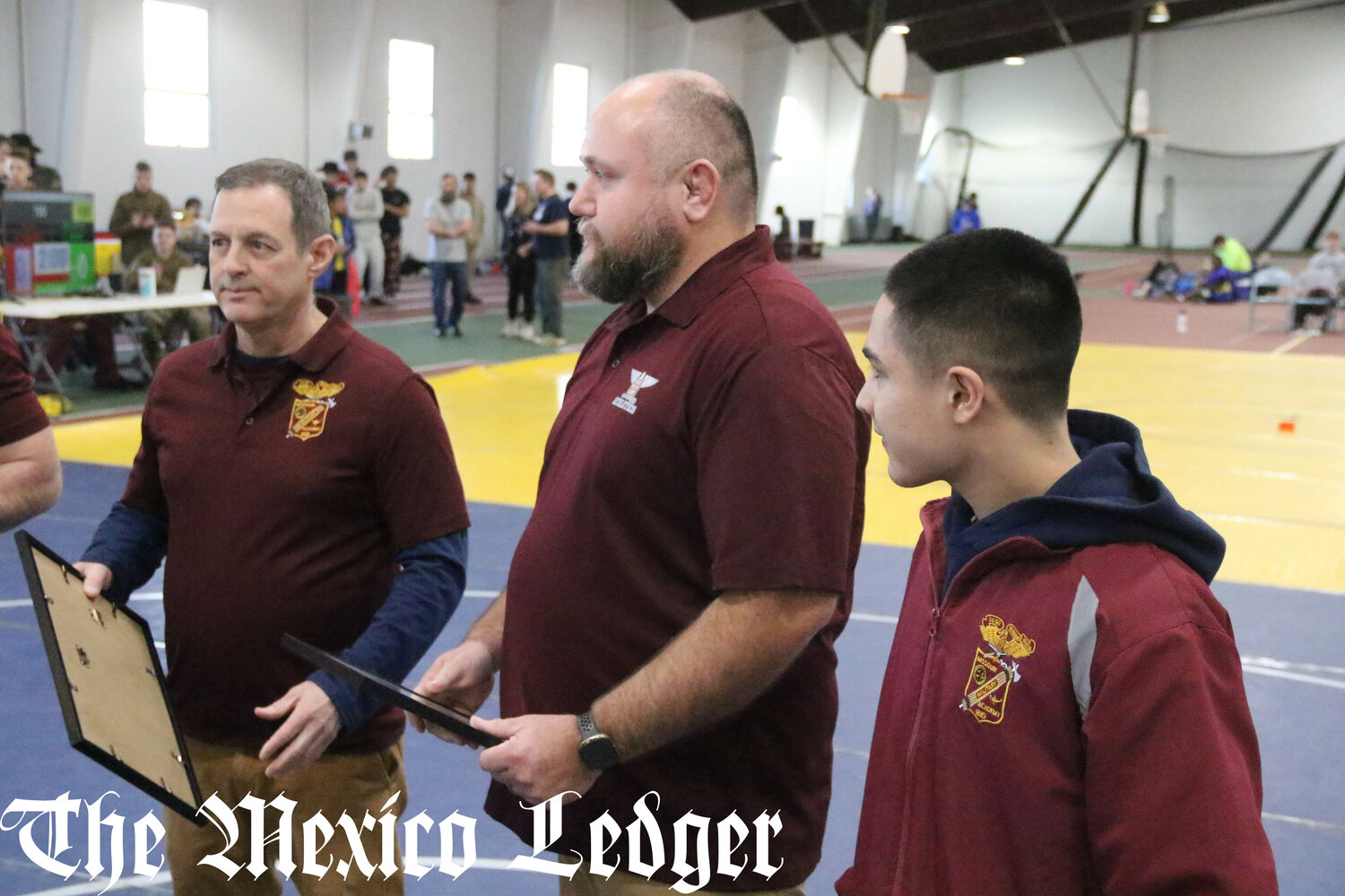 Missouri Military Academy coaches Levi Iman (middle) and Thomas Allen hold their presents from their senior wrestlers on Feb. 7 during the MMA Colonels Classic in Mexico.