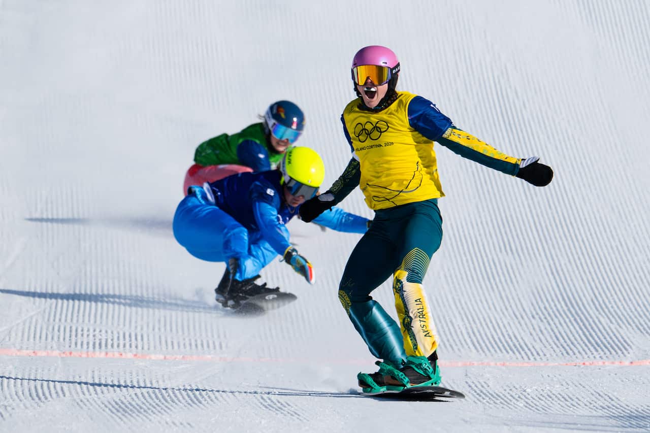 Three snowboarders coming down a slope, with one wearing an Australian jersey in the lead.