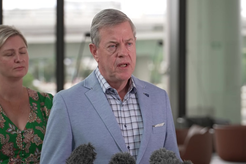 A politician wearing a suit jacket, speaking to media.