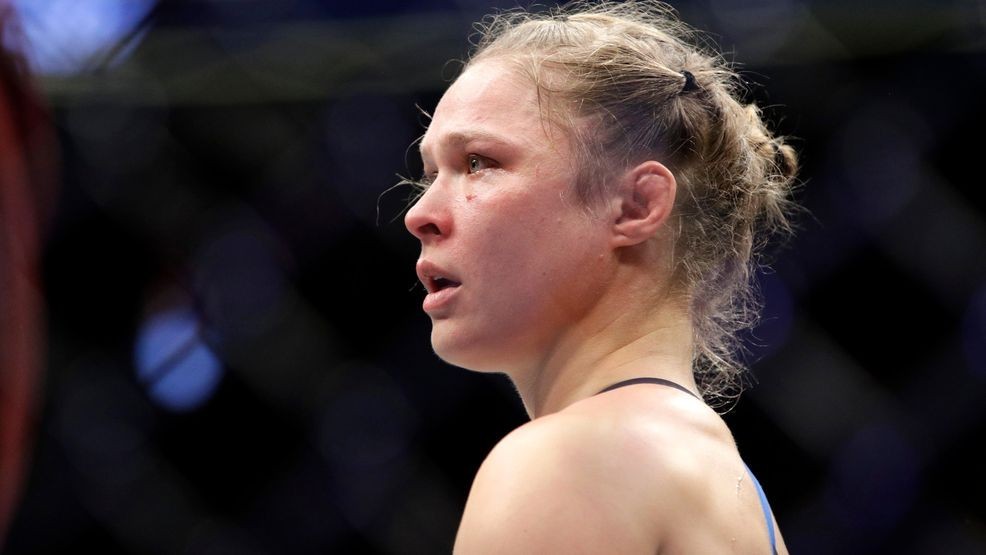FILE - In this Dec. 30, 2016, file photo Ronda Rousey stands in the cage after Amanda Nunes forced a stoppage in the first round of their women's bantamweight championship mixed martial arts bout at UFC 207 in Las Vegas. Rousey's next fight could come in a WWE ring. WWE executive Paul Levesque, better known as wrestling superstar Triple H, had dinner with Rousey in Los Angeles on Tuesday night, Jan. 8, again fueling speculation that UFC's biggest female star could leave the octagon for a career in sports entertainment. "We are talking to Ronda, as we've been for a while," Levesque told The Associated Press by phone on Wednesday. "She has a lot of things going on. We have a lot of things going on. But we have a great relationship with her, a very friendly standpoint for a long period of time now. It was great to catch up with her." (AP Photo/John Locher, File)