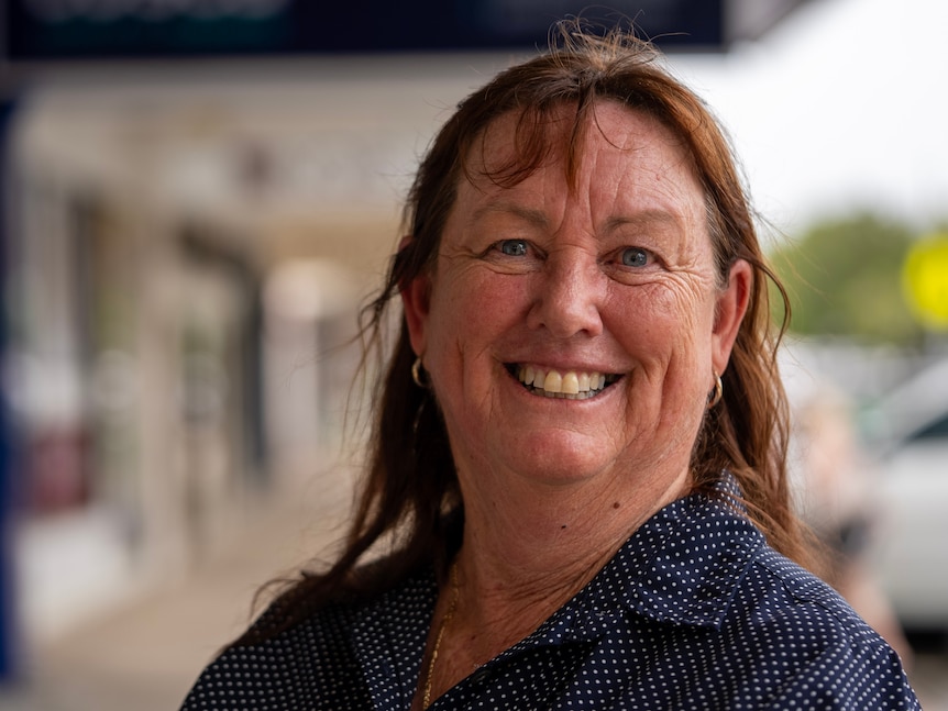 A woman with shoulder length brown hair looks at the camera.