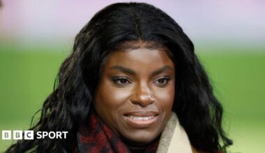 Eni Aluko smiles on the touchline while conducting punditry for TNT Sports during a Premier League match